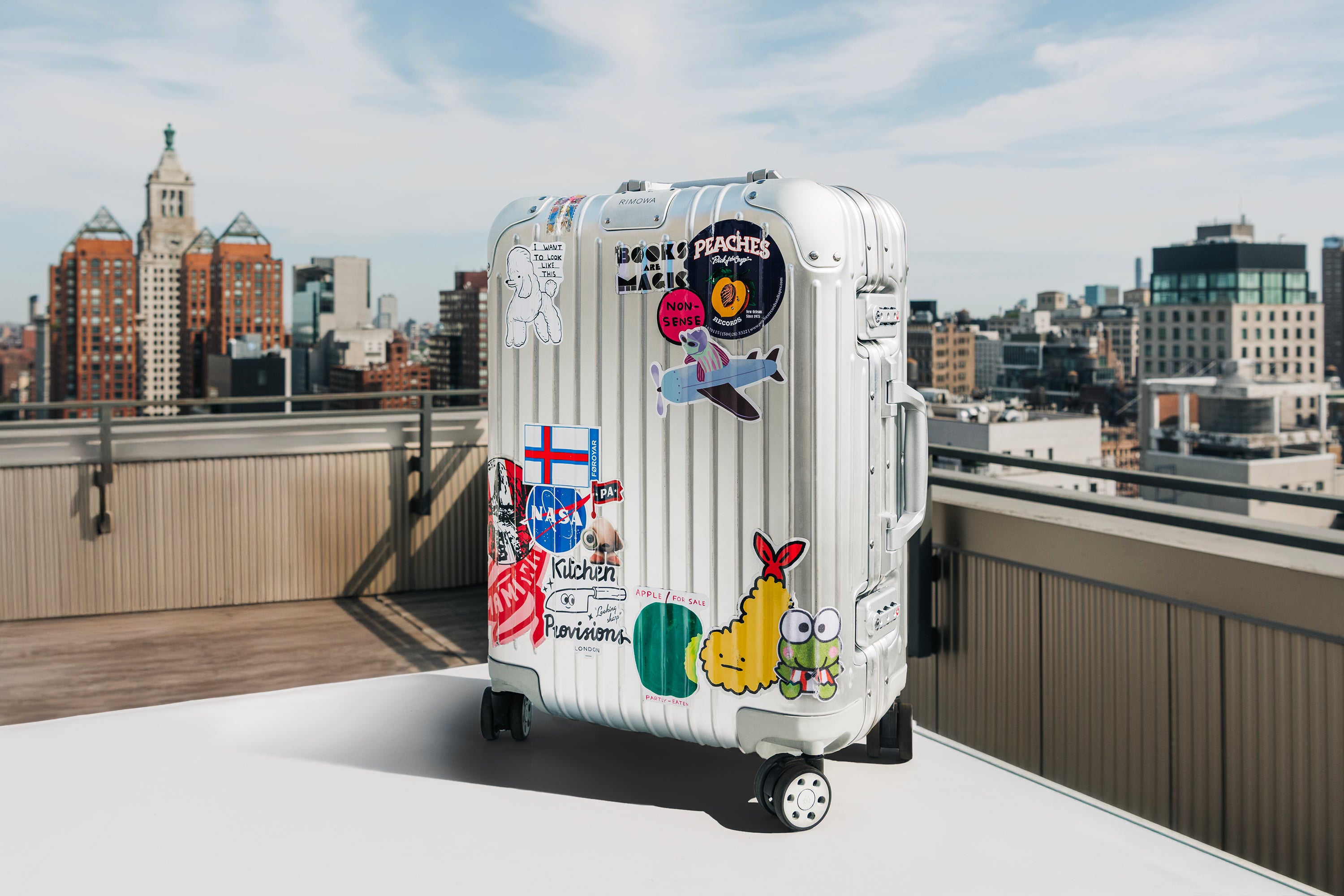Silver Rimowa carry on with stickers